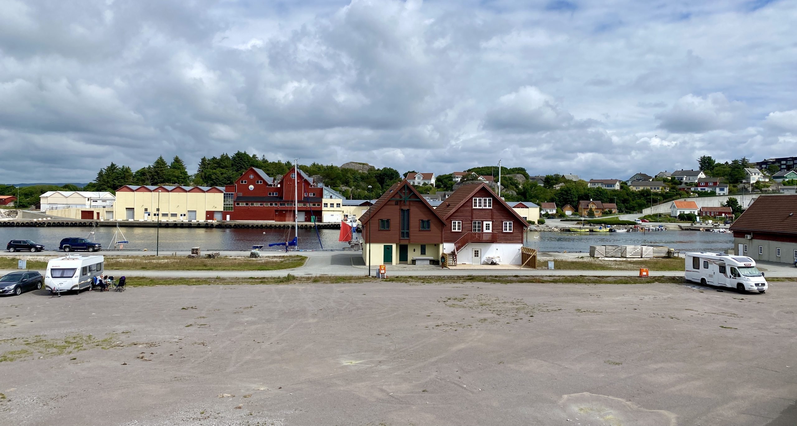  bobilparkering på Jæren ved havn ved kysten nært hus og fiskebåter.