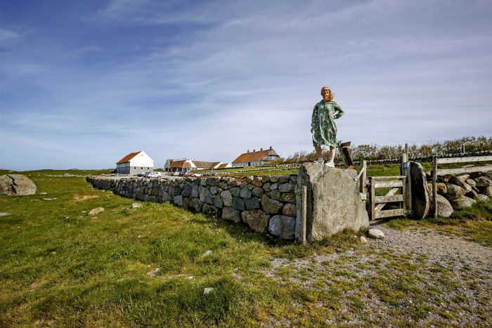 Hå gamle prestegard med kvinne på toppen av en steinmur