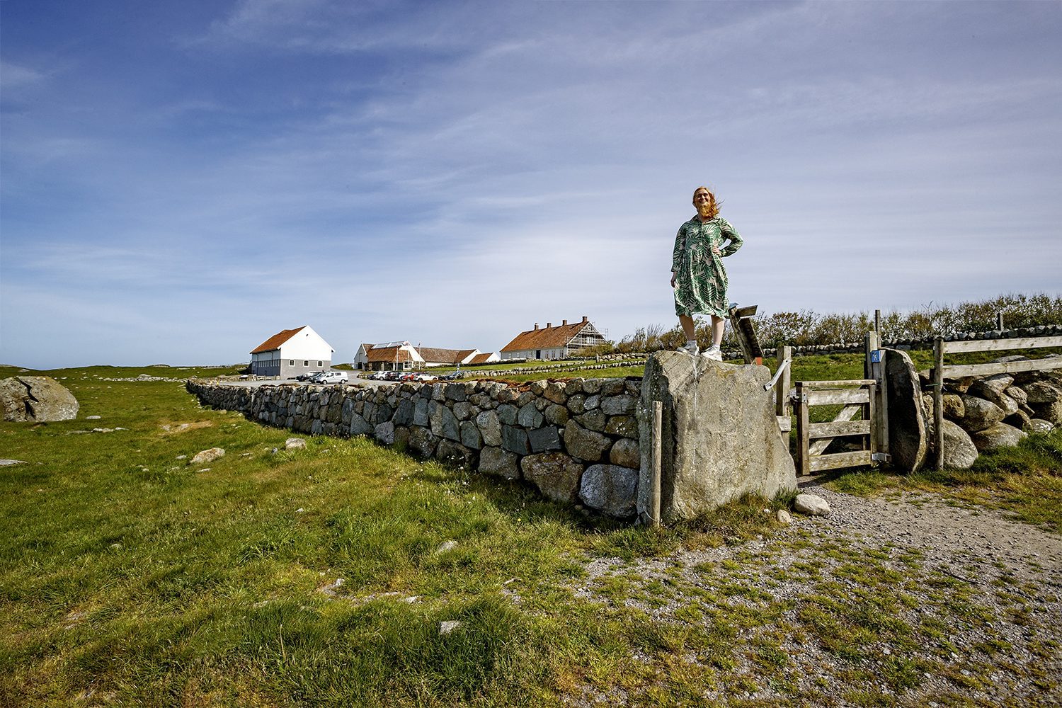 Hå gamle prestegard med kvinne på toppen av en steinmur