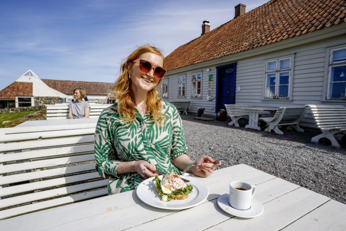 Hå gamle prestegard kafebenk og bord utenfor med gjest.